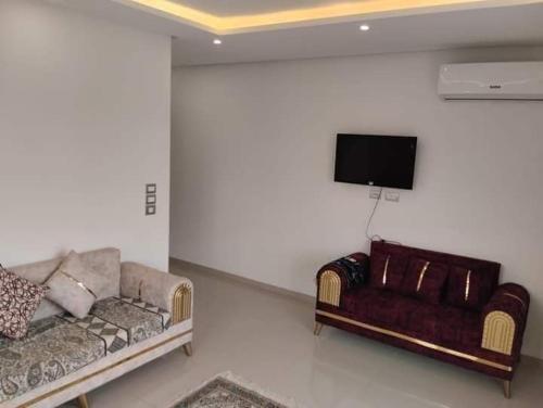 El Ahmarإقامة طلال的带沙发和平面电视的客厅