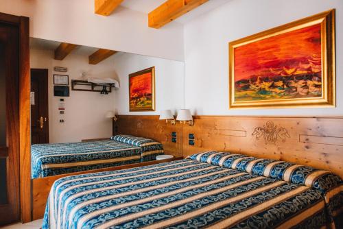阿科Arciduca Charming House Room & Breakfast的墙上画画的房间里设有两张床