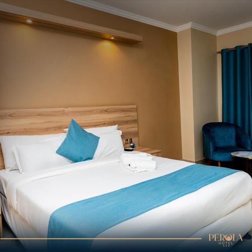 马普托PEROLA HOTEl的酒店客房配有一张带蓝色枕头的大床