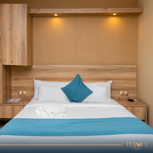 马普托PEROLA HOTEl的一间卧室配有一张带蓝色和白色枕头的床