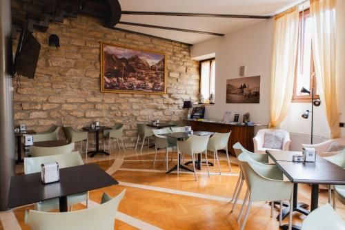 阿科Arciduca Charming House Room & Breakfast的一间带桌椅和石墙的餐厅