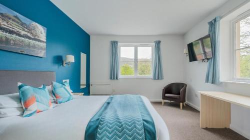 韦尔斯伍基洞酒店的蓝色的卧室设有床和窗户