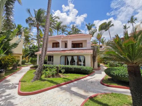 蓬塔卡纳DELUXE VILLAS BAVARO BEACH & SPA - best price for long term vacation rental的前面有棕榈树的房子