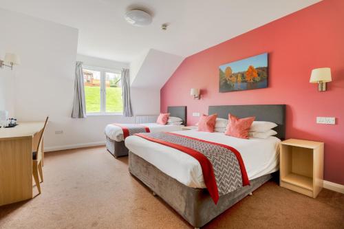 韦尔斯伍基洞酒店的红色墙壁客房的两张床