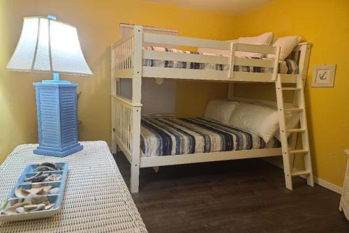 格尔夫海岸The Beach is Only Steps Away (F2) BEACHFRONT - Sleeps 8的一间卧室配有两张双层床和一盏灯。