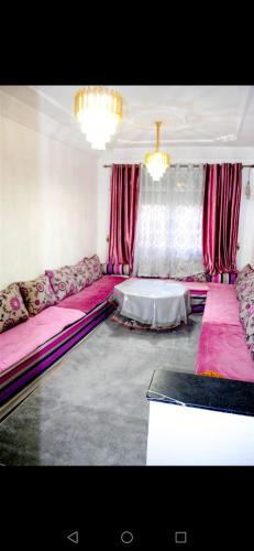 Airport apartment 2的客厅配有粉红色的沙发和桌子