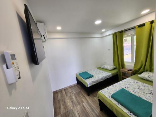 普罗维登西亚Sea Breeze inn 101的小房间设有两张床和电视