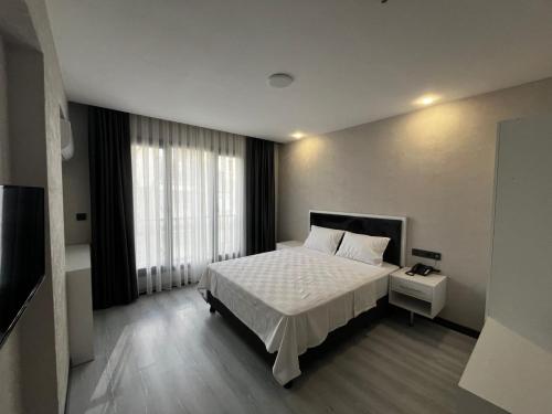 迪亚巴克尔Beyoğlu Palas Otel的卧室配有白色的床和窗户。