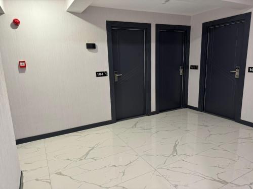 迪亚巴克尔Beyoğlu Palas Otel的走廊设有三扇门,铺有大理石地板