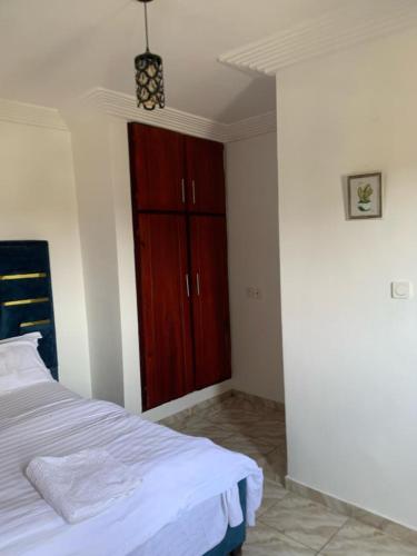 杜阿拉Gokus Home的一间卧室配有一张床和一个木制橱柜