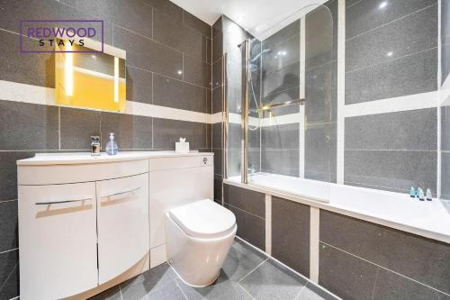 坎伯利2 Bedroom 2 Bathroom Apt in Camberley Free WiFi By REDWOOD STAYS的浴室配有卫生间、盥洗盆和浴缸。