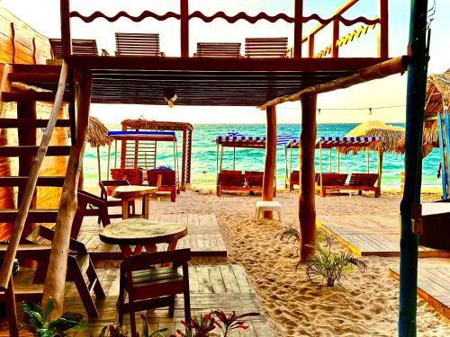 布兰卡滩BARU MAGGYBEACH的海滩上设有桌椅,大海上设有沙滩