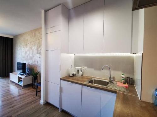 谢德尔采Apartament Siedlce的厨房配有白色橱柜和水槽
