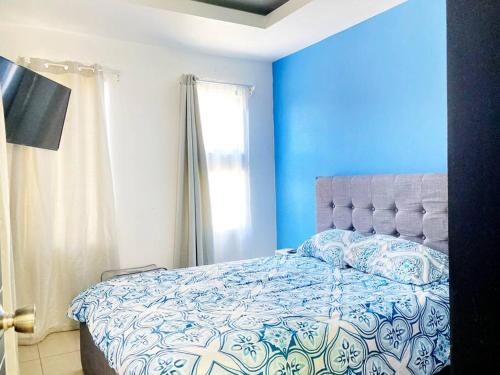 Santiago EsteCasa Matiza的蓝色的卧室设有床和窗户