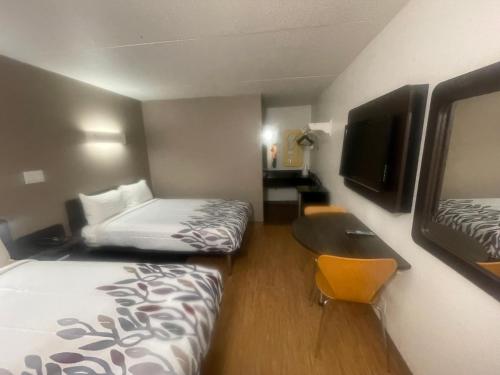 埃文斯维尔PT 6 INN的小酒店客房配有两张床和书桌