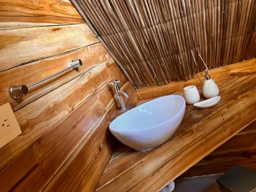 布兰卡滩BARU MAGGYBEACH的木墙内带白色水槽的浴室