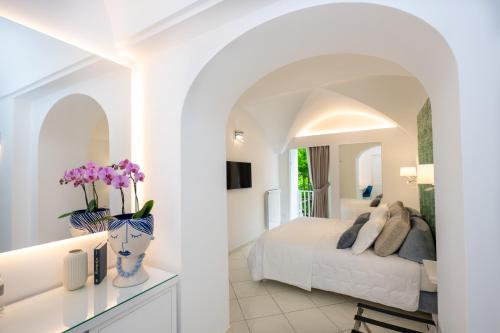普莱伊亚诺La Divina Amalfi Coast的白色卧室配有床和镜子