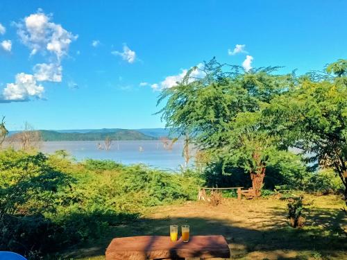 Ol KokwePopo Camp Lake Baringo的享有河流美景,设有1棵树和1张桌子