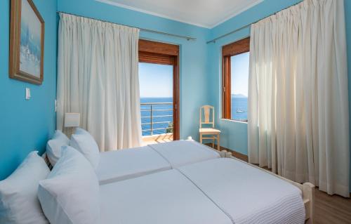 ÉvyirosIris Villas Lefkada - Marine Villa的蓝色的卧室设有床和大窗户
