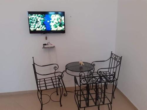 阿加迪尔Hay Salam agadir only for family的一张桌子和椅子,墙上配有电视