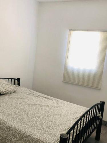 墨西卡利Bonito y cómodo departamento 2R的一间卧室配有一张床和一个带被子的窗户