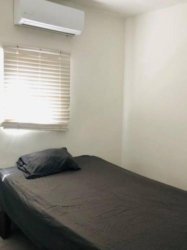 墨西卡利Bonito y cómodo departamento 2R的一间卧室配有一张床和一个带枕头的窗户