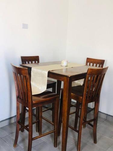 墨西卡利Bonito y cómodo departamento 2R的一张带四把椅子的木桌和一张白色的桌布