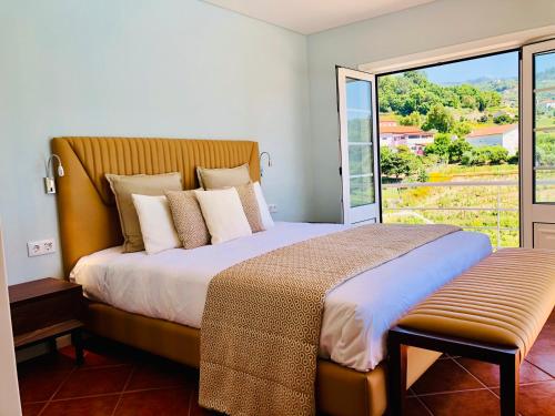 Santa Cruz do DouroSolar Do Douro的一间卧室设有一张大床和大窗户