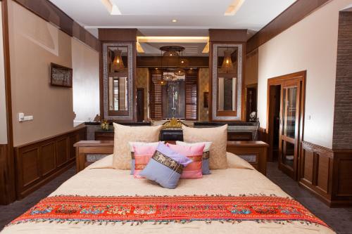 拉迈Ammatara Pura Pool Villa的一间卧室配有一张带枕头的大床