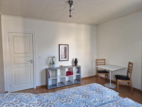 奥勒松Cozy Retreat in the Heart of Ålesund的一间卧室配有一张床、一张桌子和一张书桌