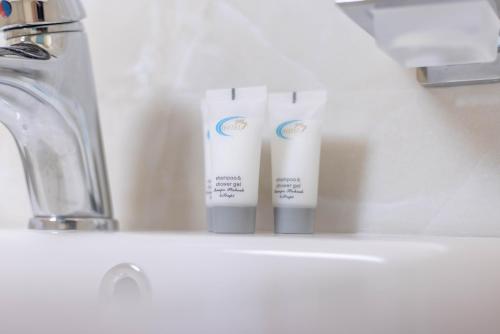 都拉斯Hotel Vila MAX的浴室水槽上两管牙膏