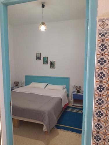 Al MāʼīyahDAR HIDOUS的一间卧室配有一张蓝色床头板的床