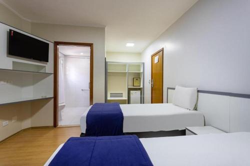 圣保罗卡里隆广场酒店的酒店客房设有两张床和一台平面电视。