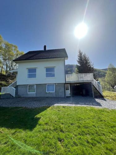 TjørvågFeriehus og naust i idylliske omstendigheter的带阳台和庭院的大型白色房屋