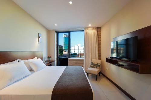 圣克鲁斯Chairu Eco Hotel的一间酒店客房,配有一张大床和一台平面电视