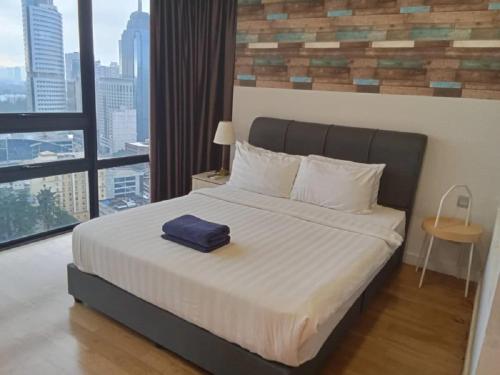 吉隆坡Anggun Residence Kuala Lumpur的一间卧室配有一张带蓝色毛巾的床