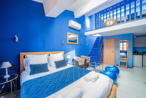 佩皮尼昂Suites Coronell d'En Vila的蓝色的卧室,配有床和蓝色的墙壁
