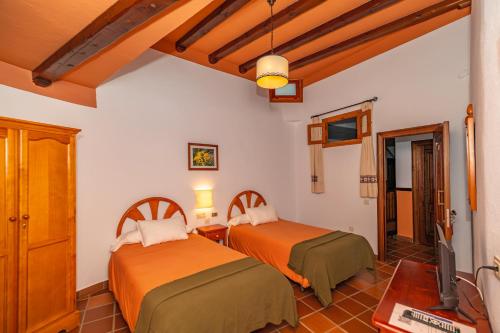 特雷韦莱斯拉弗拉瓜一号酒店的一间带两张床的卧室和一台电视
