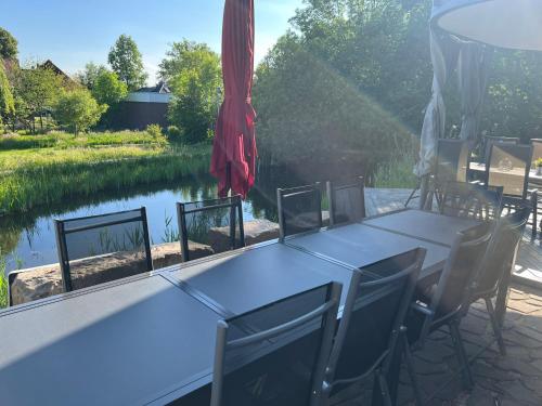 布伦瑞克"Landhaus Thuner Heide" mit Kamin, Whirlpool & Feuerstelle的一张桌子和椅子,享有河景