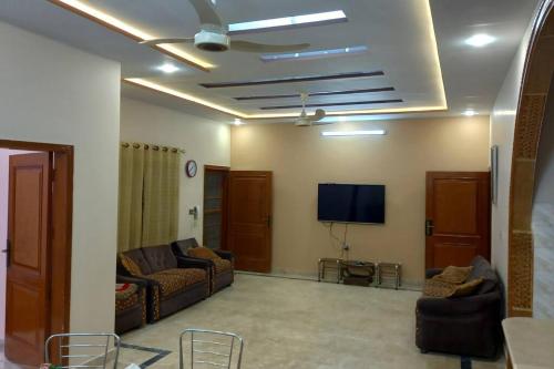 卡拉奇Regal Palace Gulshan Nipa的带沙发和平面电视的客厅