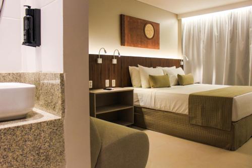 若昂佩索阿Smart Hotel João Pessoa的一间卧室配有一张床,浴室设有水槽