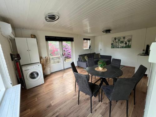拉克斯杰斯特Boshuis Luyksgestel 2-6 personen, veel privacy!的厨房以及带桌椅的起居室。