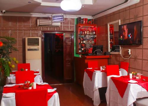 拉各斯Definite Destiny Hotel by YOTRAD的一间餐厅,房间内设有红色桌子和红色椅子
