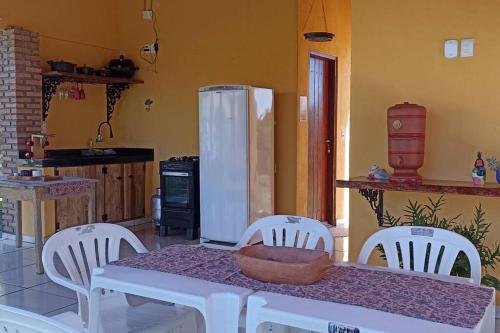 ChavantinaChácara Beira Rio - NX -MT的厨房配有带白色椅子的桌子和冰箱。