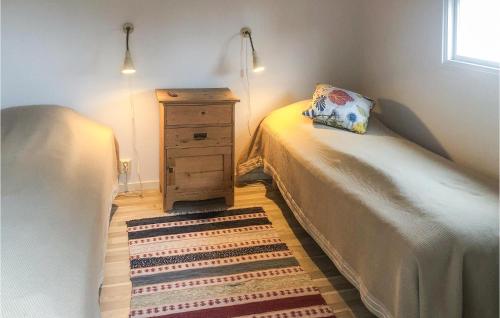 韦斯特维克2 Bedroom Cozy Home In Vstervik的一间卧室配有一张床和一个带枕头的梳妆台