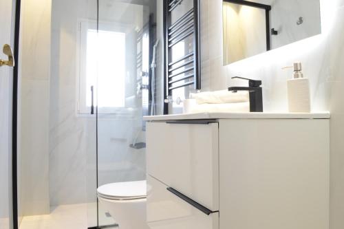 马德里Bonito Apartamento Madrid Rio的白色的浴室设有卫生间和水槽。
