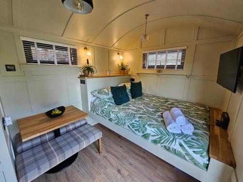 查尔伍德Gatwick Hideaway Hut的小房间设有一张床和一张桌子