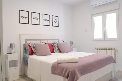 马德里Bonito Apartamento Madrid Rio的白色卧室配有带枕头的大床