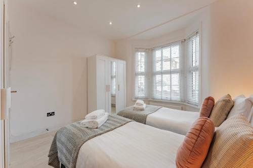 伦敦Cosy & Stylish Apmt w/ Fast Wifi的一间卧室设有两张床和窗户。