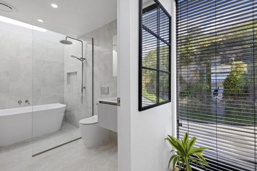 惠灵顿Vista Mare的带浴缸、卫生间和窗户的浴室
